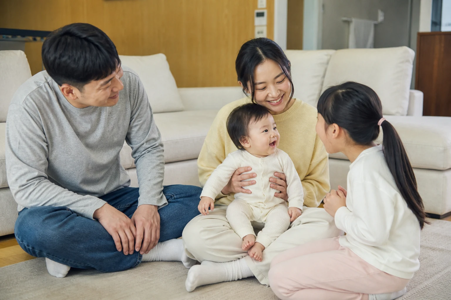 A photorealistic scene of an awake baby and real people sharing responsive vocal or social communication